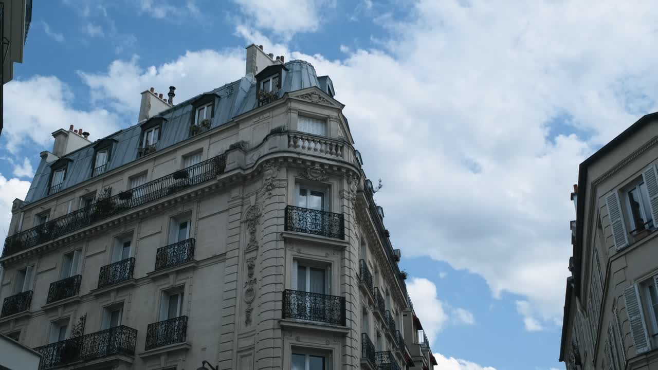 una foto amplia de un edificio de haussmann bajo un cielo azul en parís