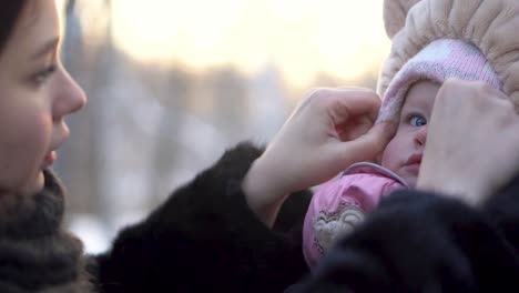 mother dressing her baby in winter