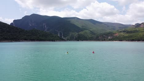 Congost-de-Mont-Rebei-Canyon-at-Ager,-Catalonia-and-Aragon,-Spain---Aerial-Drone-View-of-Tourists-Kayakking-at-the-Blue-Emerald-Noguera-Ribagorçana-River