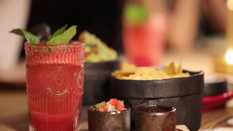 a vibrant scene of guacamole, chips, and a refreshing drink on a restaurant table in bangkok, thailand