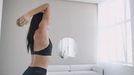 a young girl raises her arms with dumbbells from behind her head doing triceps exercises. triceps training.