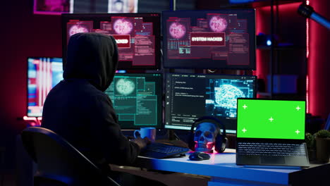 hacker che fa sabotaggio informatico usando ransomware trojan su laptop a schermo verde