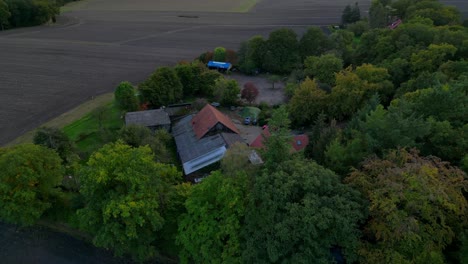 traditional north german farm is nestled in the forest, photographed from above. great aerial view flight drone shot footage from above