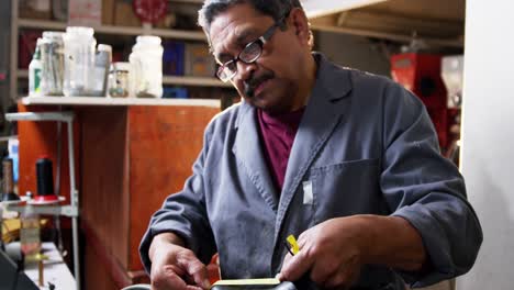 shoemaker measuring a shoe with measure tape