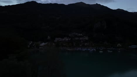 aerial view of a residential area unveiling the calm waters of lake walensee in switzerland during late evening, as dusk softly descends, crafting a serene and picturesque landscape.