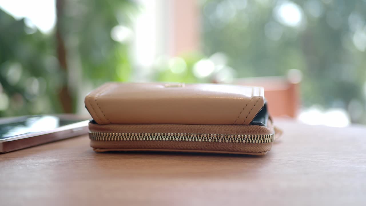 billetera de cuero beige en una mesa de madera