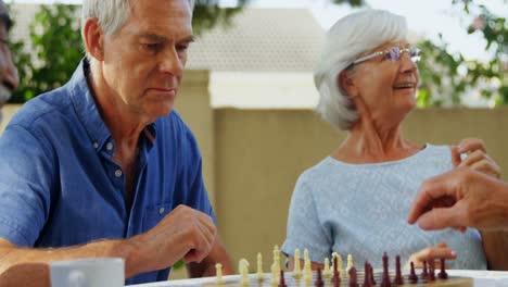 senior friends playing chess 4k