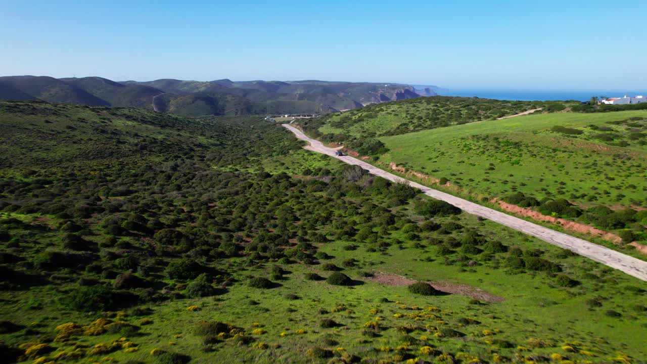 Car Driving On The Road Leading Towards The Ocean In Summer. - aerial shot