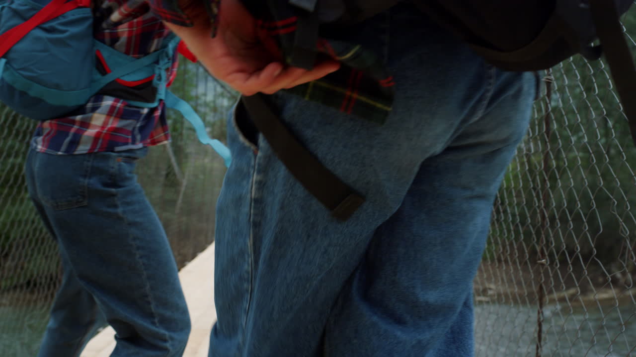 los amigos viajeros bailan juntos en el puente de las montañas. la pareja se mueve divertida en la naturaleza.