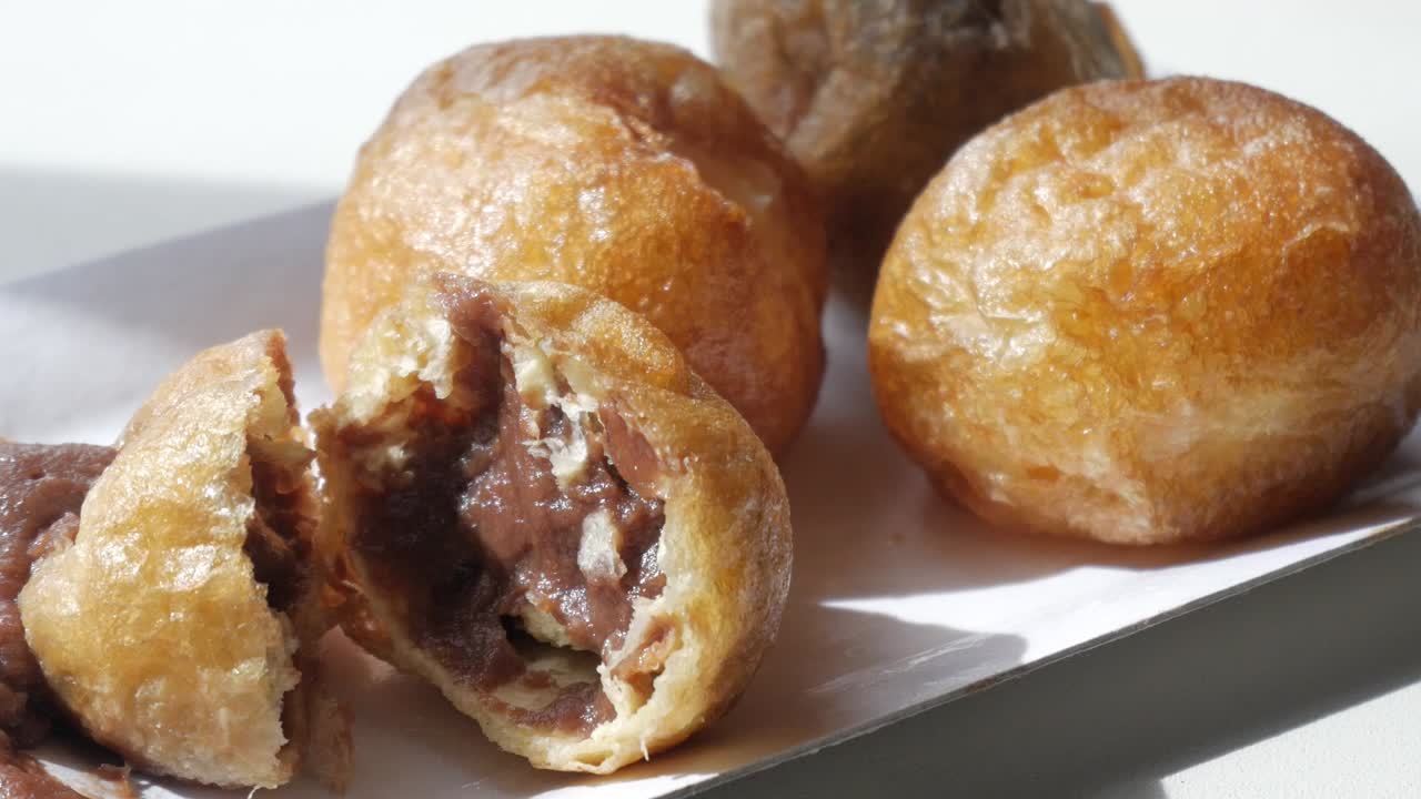 Close up of stuffed Puff Puff with chocolate inside, sweet delicious dessert for every occasion, zoom in, white background, one is cut to see inside