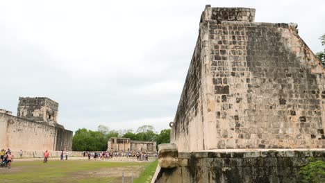 tourists visiting the great ball court in chichen itza.