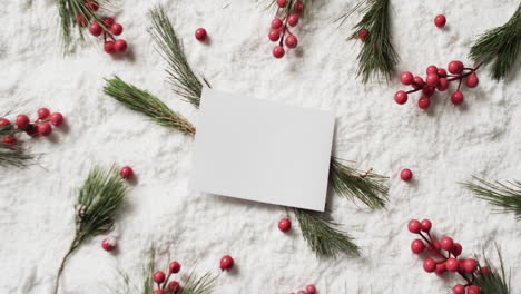 video of christmas decorations and white card with copy space on snow background