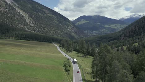 aerial view of a winding mountain road with trucks and cars