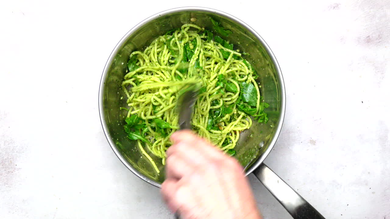 Spaghetti And Pesto Being Tossed In A Pan