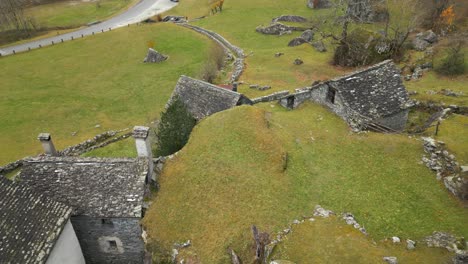 Zipline-drone-shot-approaching-the-entrance-of-a-village-in-Cavergno,-located-in-the-distrcit-of-Vallemaggia,-bordering-Italy-in-the-canton-of-Ticino,-in-Switzerland