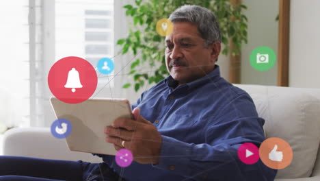 animación de la red con iconos de las redes sociales sobre el hombre biracial usando la tableta.