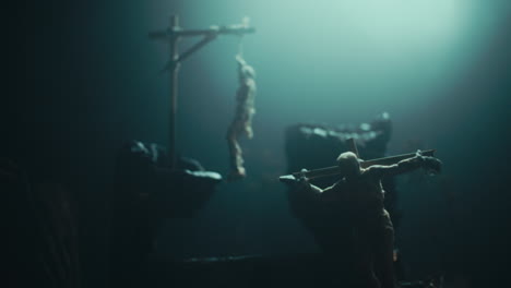 miniature mummified dolls hanging on the gallows at night