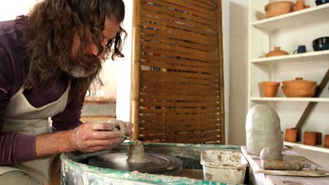 male potter making pot