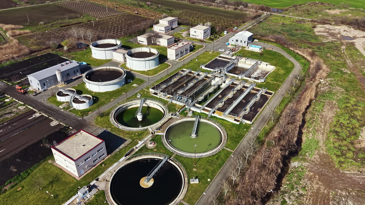 Water treatment facility operates in a rural area with various tanks and buildings for cleaning wastewater and managing resources