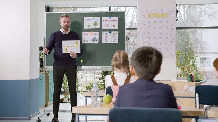 Teacher Teaches A Multiethnic Students Group The Words 'Happy' And 'sad' In English Classroom