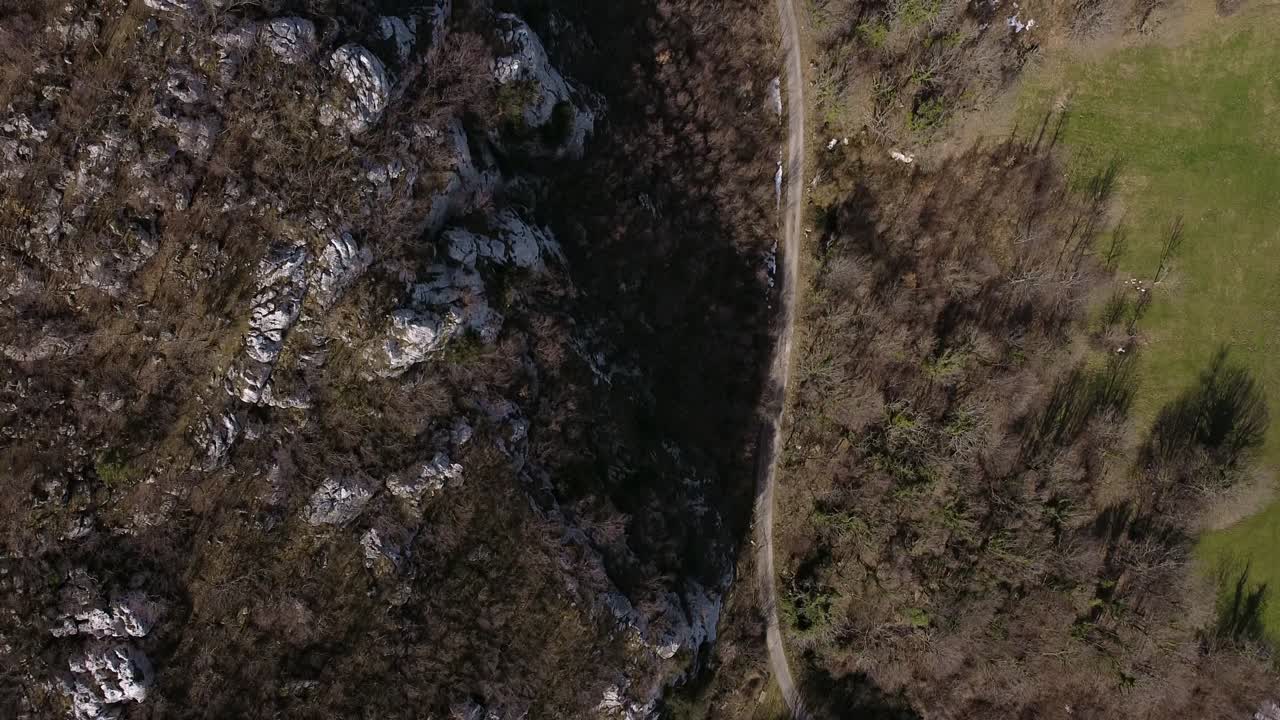 vista aérea sobre una carretera rural, rodeada de montañas rocosas de los apeninos, italia