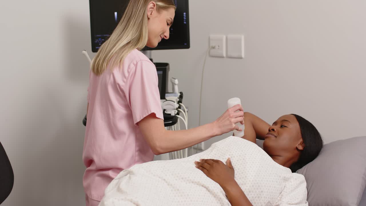 Technicienne en blouse médicale appliquant du gel, plaçant une sonde et scannant une patiente pour un examen en clinique.