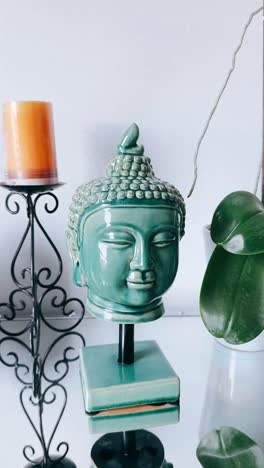 teal buddha head decor with orchid plant