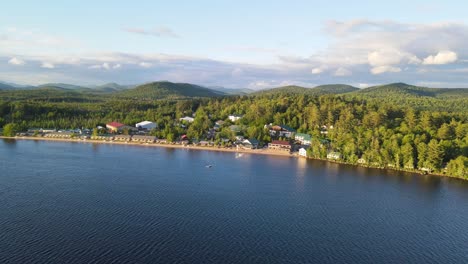 aerial shot of a large lake with rental buildings alongside the beachfront in new york