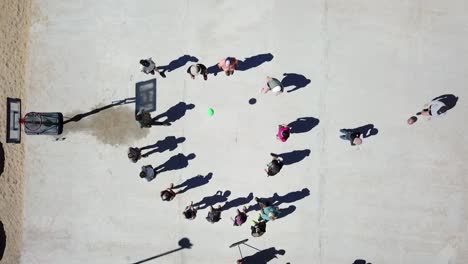 top down drone shot of kids playing out in the schoolyard at break