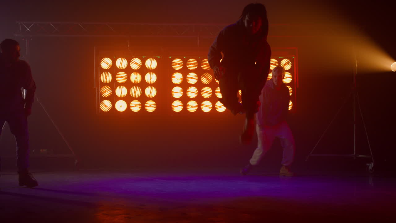 siluetas de tres talentosos hiphopistas actuando en el escenario. hombres bailando estilo libre.