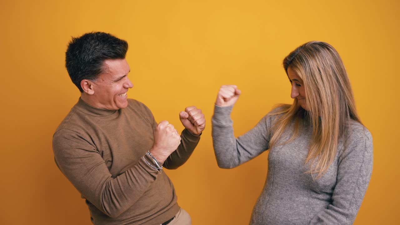 Coppia felice che celebra il successo con un cinque alto e una stretta di mano