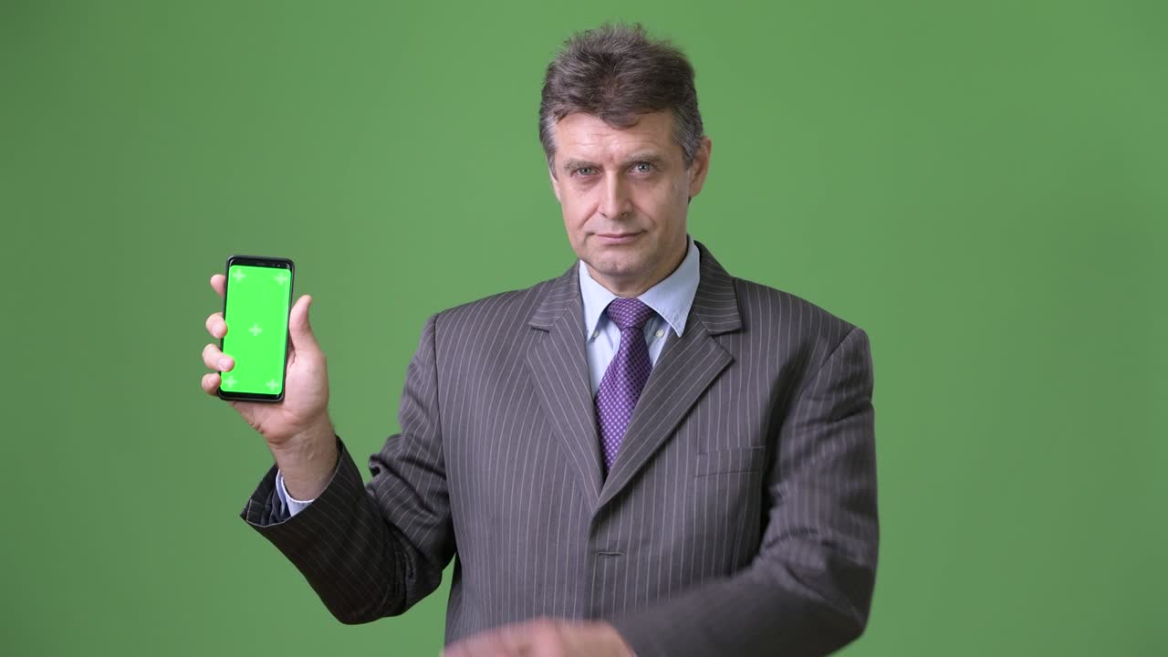 녹색 배경에 성숙한 잘생긴 사업가