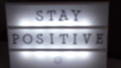 focus rack shot of a luminous sign with the inscription stay positive