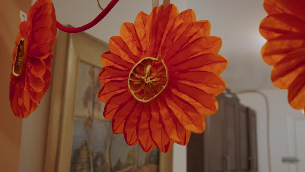 una serie de decoraciones navideñas: campanas, flores de papel, naranjas secas