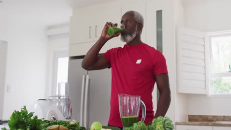 senior african american man drinking fruit and vegetable health drink at home