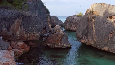 aerial approaching shot of of giant boulders with clear caribbean sea water at bahia de las aguilas