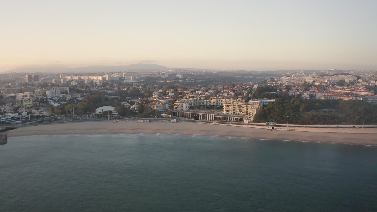 vista aérea de marginal sobre el océano en la playa de santo amaro de oeiras, puesta de sol en portugal - disparo de drones en estado de ánimo de silueta