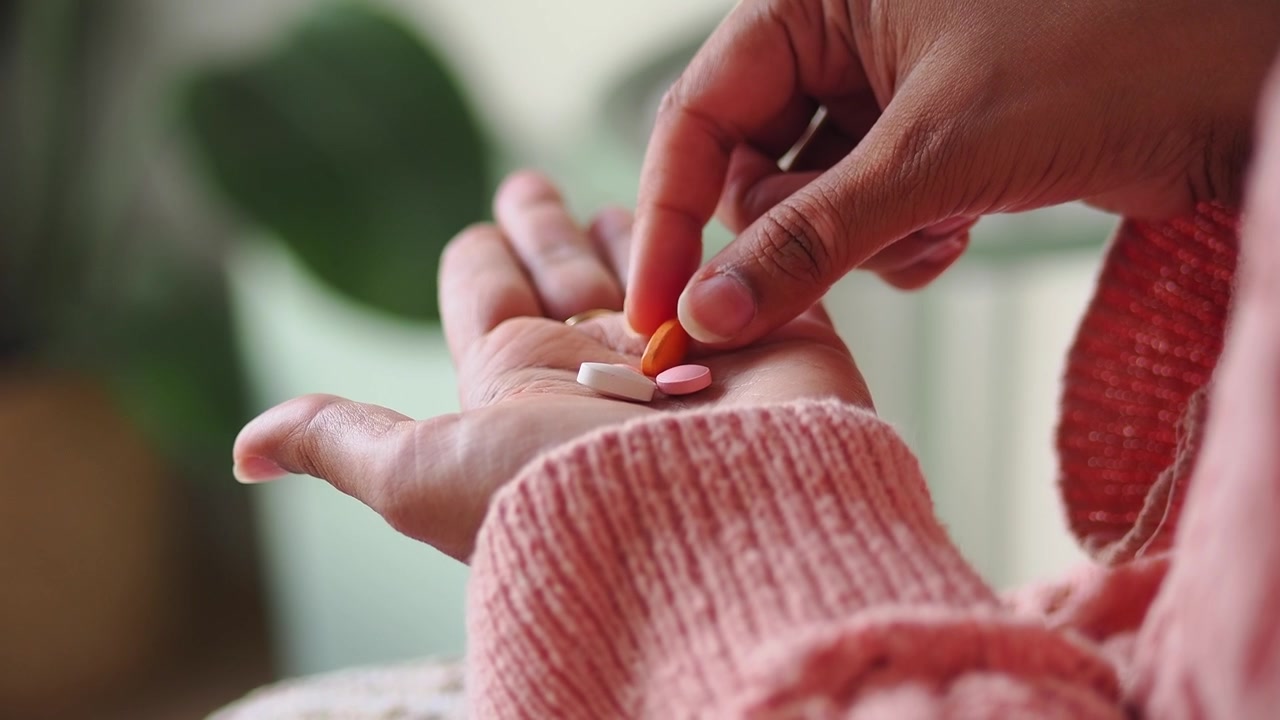 Person Holding Assorted Pills in Palm of Hand