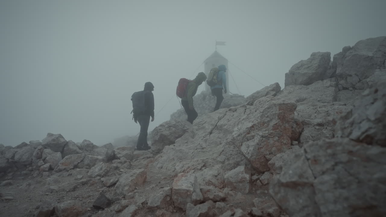 los excursionistas están subiendo hacia la cima de la montaña triglav para llegar a la torre aljaž