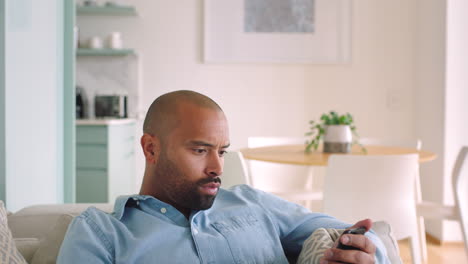 hombre en el sofá de la sala de estar usando el teléfono en social