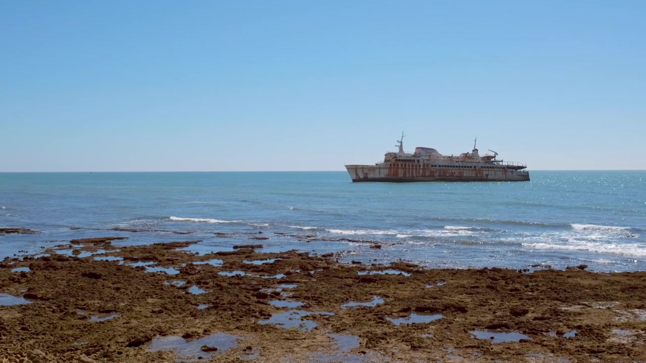 Relitto di nave in Marocco in una giornata calma, con panoramica, ripresa a mano