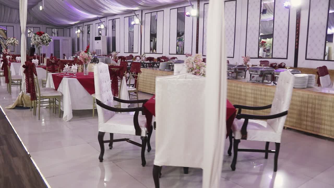 The view showcases an elegant wedding arrangement featuring tables adorned with artificial flower arrangements.