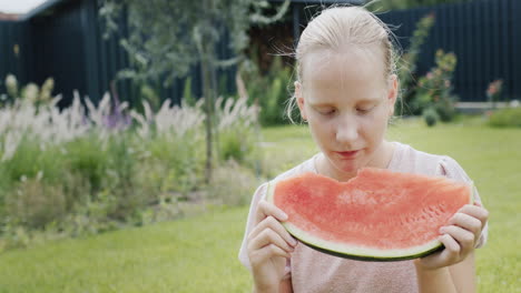 the child eats a ripe tasty watermelon at a picnic.