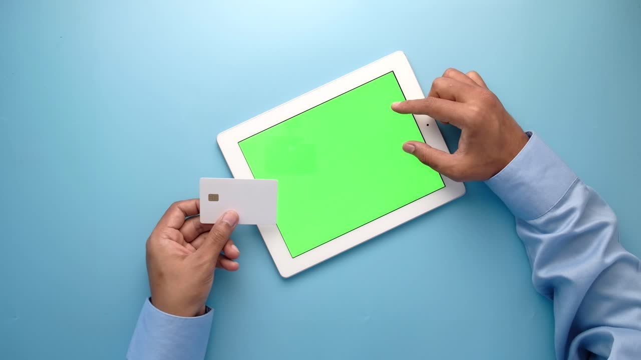 persona que utiliza una tableta y una tarjeta de crédito para el pago en línea