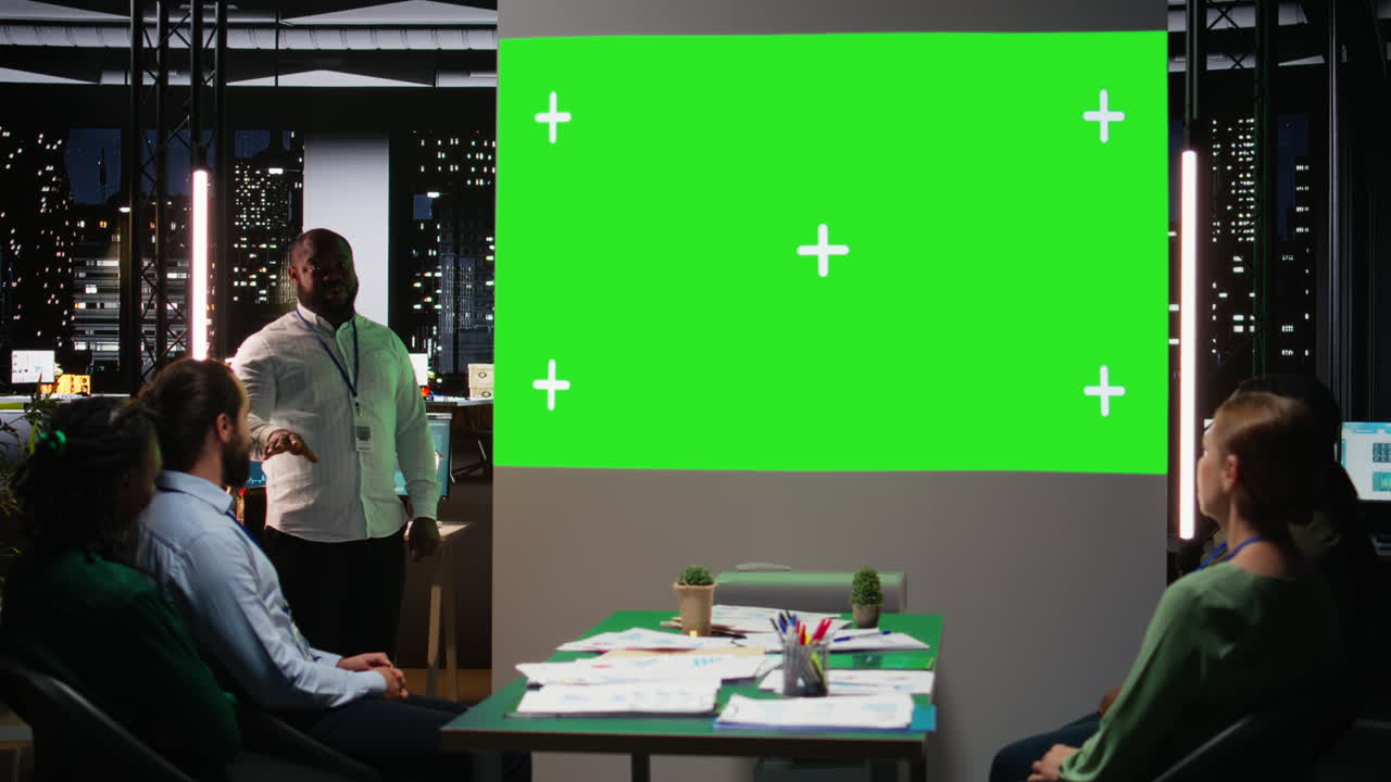 Multiethnic project team works late in a dark office with copy space