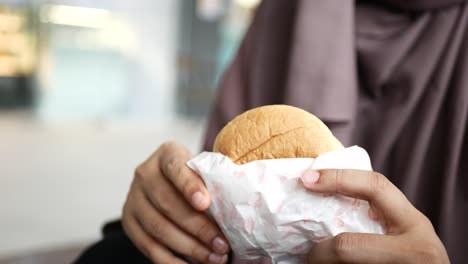 Women-hand-holding-beef-burger-top-view-,