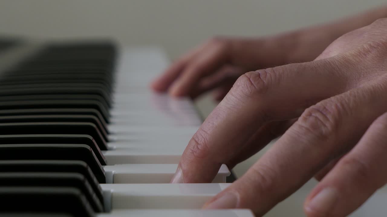 Man practicing playing music, learning chords on piano, close up
