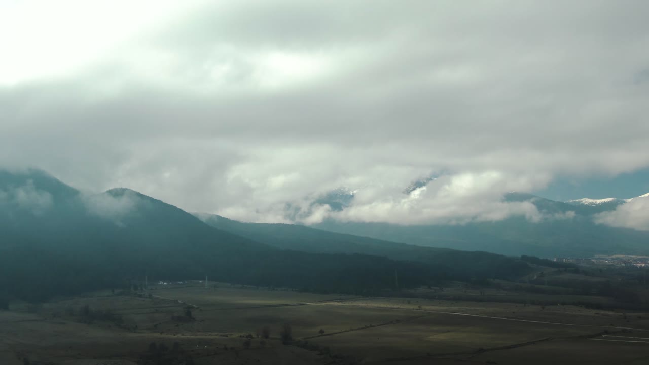 흐린 하늘이 있는 들판과 산의 드론 샷