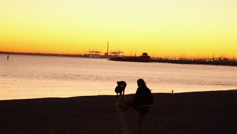 two people playing football at sunset