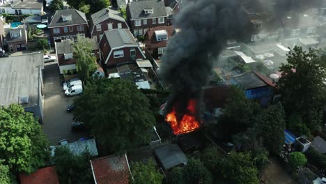 Aerial-shot-of-a-fire-burning-in-a-Dutch-shed-located-in-a-neighbourhood